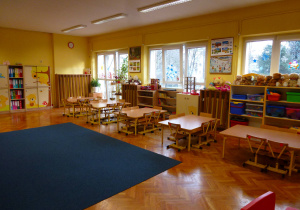 sala 4-latków, z niebieskim dywanem, żółtymi ścianami, stolikami i krzesłami oraz kolorowymi klockami na półkach