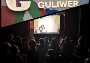 Dzieci oglądają coś na ekranie, zdjęcie jest ciemne a dzieci widoczne z tyłu.