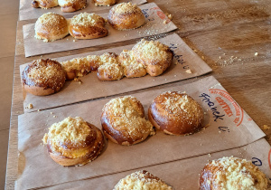 Na zdjęciu widać drożdżówki posypane kruszonką leżące na stole