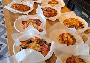 Na zdjęciu widać pizze różnego rodzaju leżące na jednorazowych talerzykach