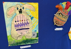 Wiszące prace dzieci przedstawiające zajączka pisankę oraz jajko pisankę.