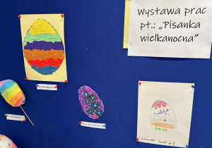 Wiszące prace dzieci przedstawiające zajączka pisankę oraz jajko pisankę.